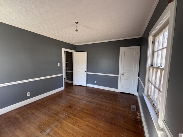 unfurnished room featuring visible vents, crown molding, baseboards, and dark wood-style flooring