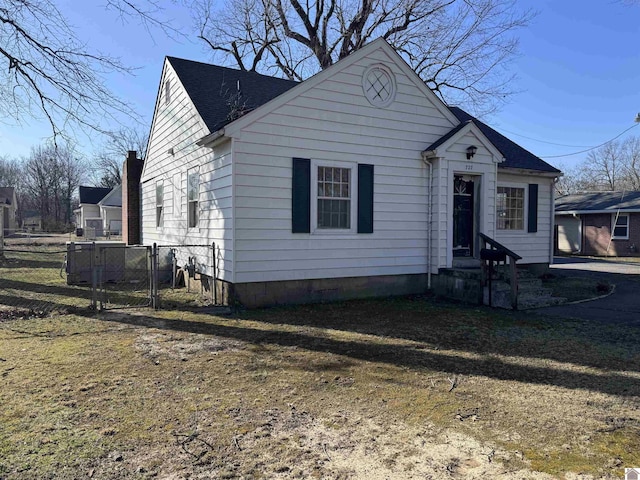 bungalow with a shingled roof and fence