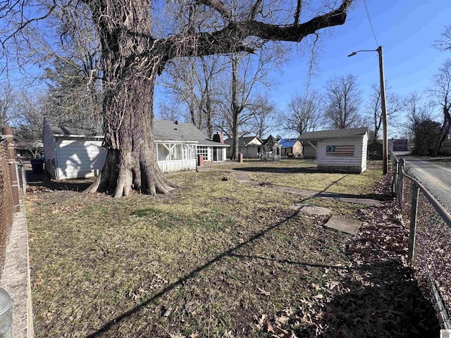 view of yard featuring an outdoor structure and fence