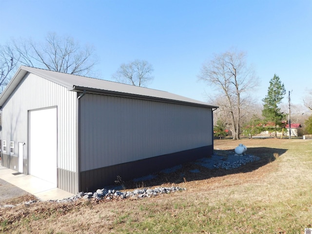 view of home's exterior with metal roof, an outbuilding, and a lawn