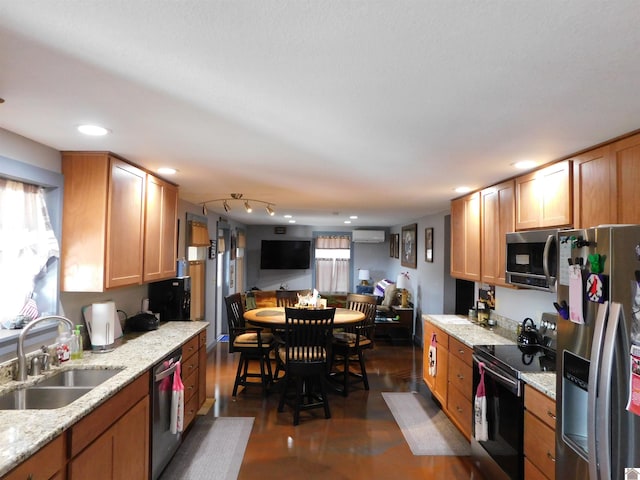 kitchen with a wall mounted AC, a sink, recessed lighting, stainless steel appliances, and light stone countertops