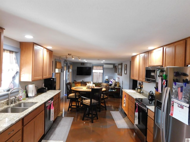 kitchen with an AC wall unit, a sink, light stone counters, recessed lighting, and stainless steel appliances