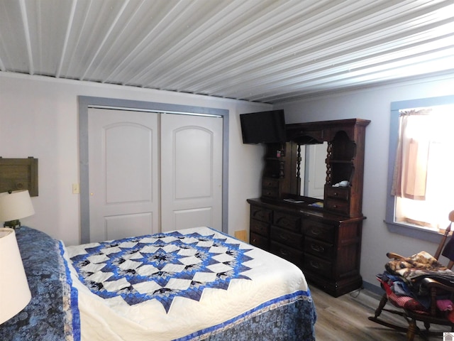 bedroom with wood finished floors and a closet