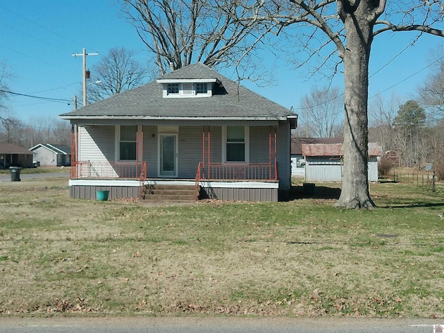 bungalow featuring covered porch, a front lawn, and a shingled roof