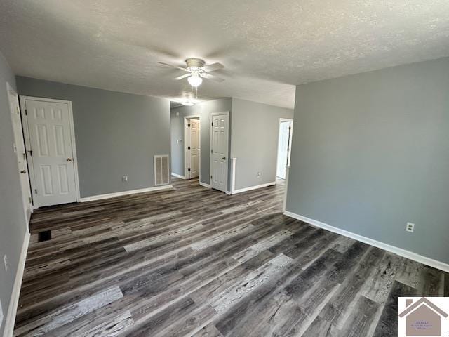 interior space featuring visible vents, ceiling fan, baseboards, dark wood-style floors, and a textured ceiling