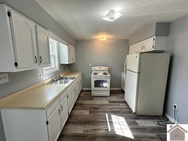 kitchen with white appliances, a sink, dark wood-type flooring, white cabinets, and a textured ceiling