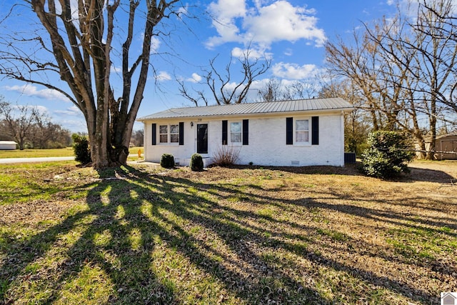 view of front facade with crawl space, brick siding, metal roof, and a front yard