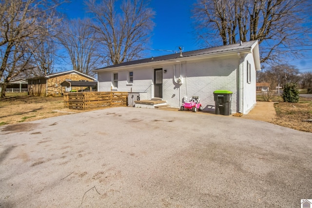 view of front of house featuring brick siding, driveway, metal roof, and entry steps