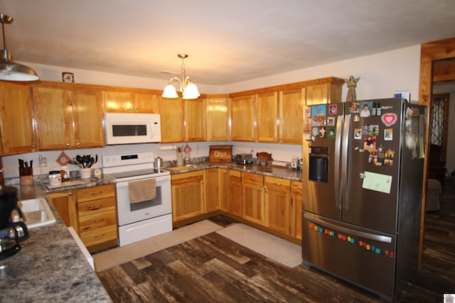 kitchen with brown cabinets, a notable chandelier, pendant lighting, dark wood finished floors, and white appliances