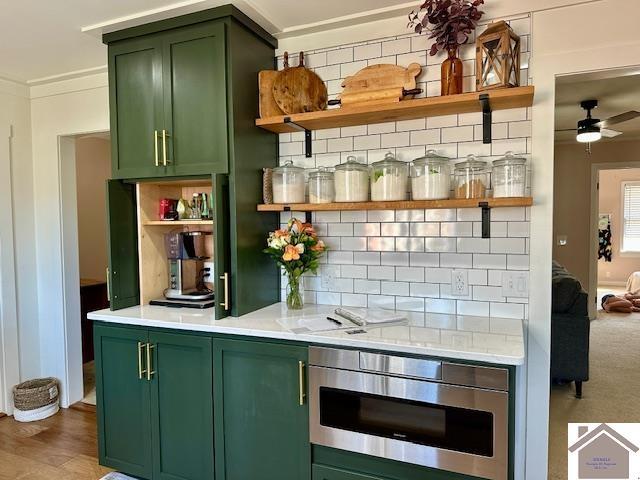 bar with decorative backsplash, a ceiling fan, light wood-style floors, and ornamental molding