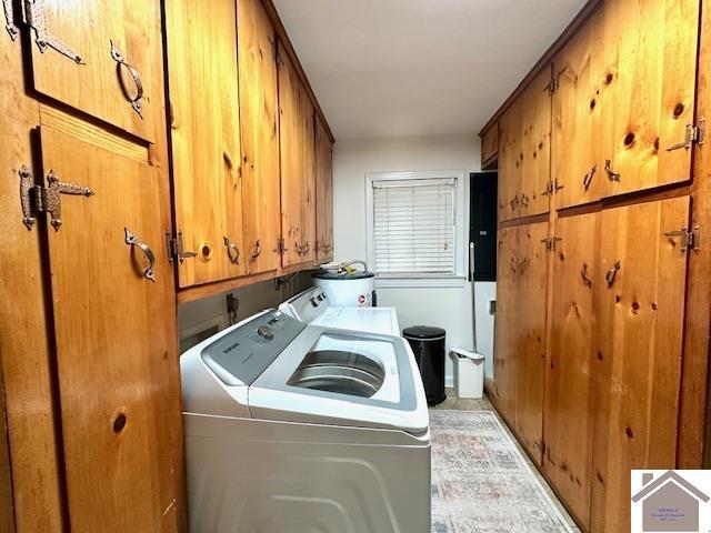 washroom with washer and dryer, cabinet space, and water heater