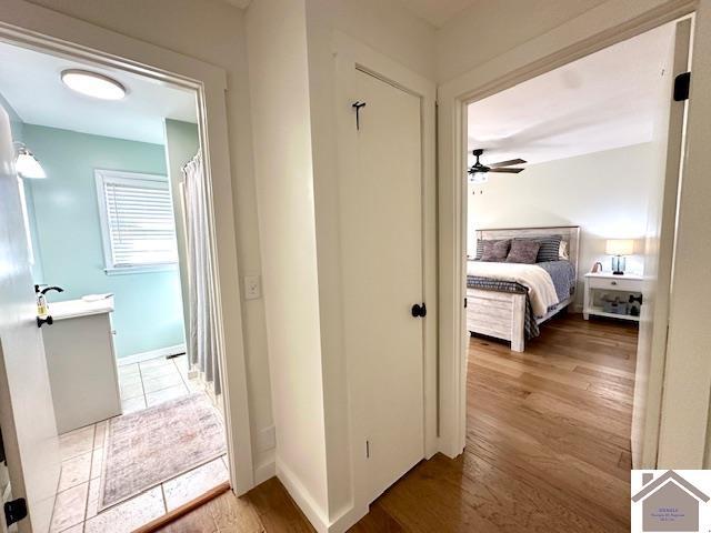 hallway featuring baseboards and wood finished floors