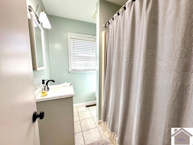 bathroom featuring tile patterned flooring, visible vents, vanity, and baseboards