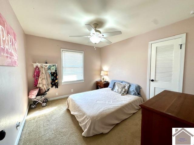 carpeted bedroom featuring baseboards and ceiling fan