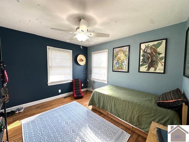 bedroom with baseboards, wood finished floors, and a ceiling fan