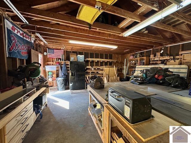 garage featuring black fridge with ice dispenser