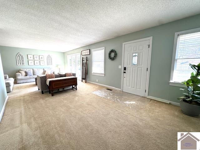 bedroom featuring visible vents, carpet, baseboards, and a textured ceiling