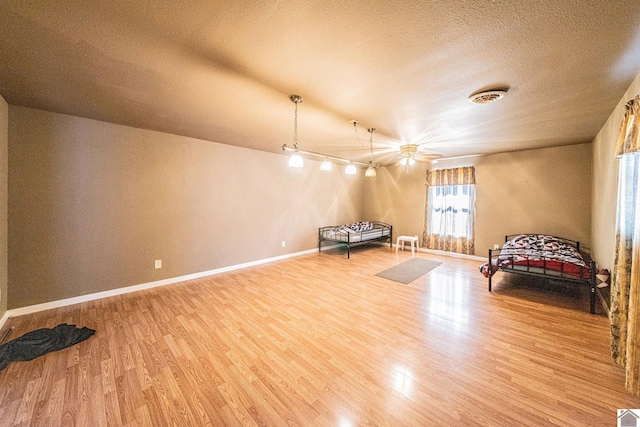 unfurnished room featuring visible vents, wood finished floors, baseboards, and a textured ceiling