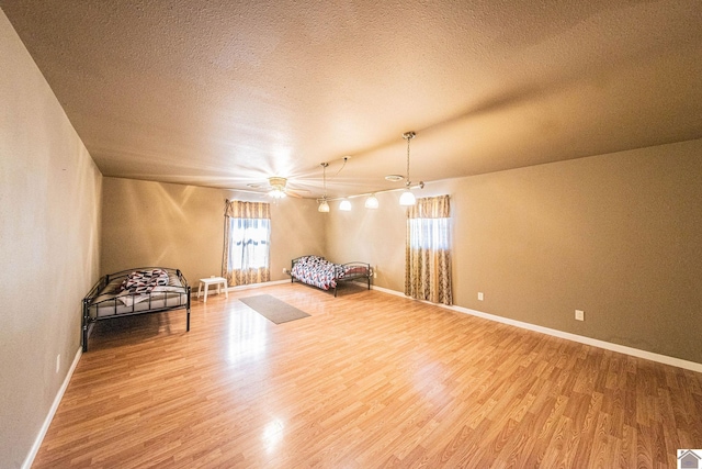 unfurnished room featuring wood finished floors, baseboards, and a textured ceiling