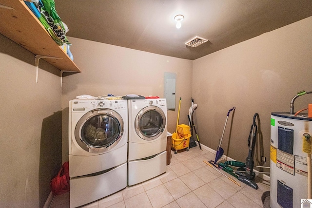 laundry room featuring electric water heater, electric panel, laundry area, light tile patterned floors, and separate washer and dryer