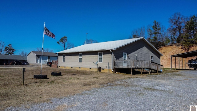 view of side of property with a deck, metal roof, and crawl space