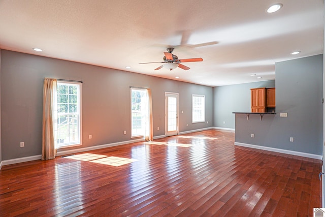 unfurnished living room with recessed lighting, baseboards, and dark wood finished floors