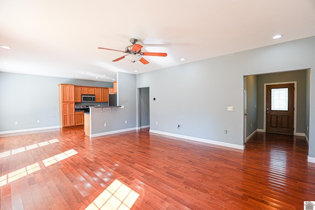 unfurnished living room featuring recessed lighting, ceiling fan, light wood-type flooring, and baseboards