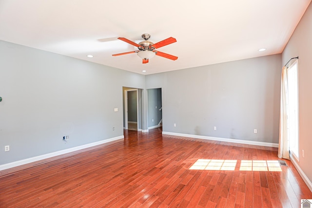 unfurnished room featuring a healthy amount of sunlight, baseboards, and wood finished floors