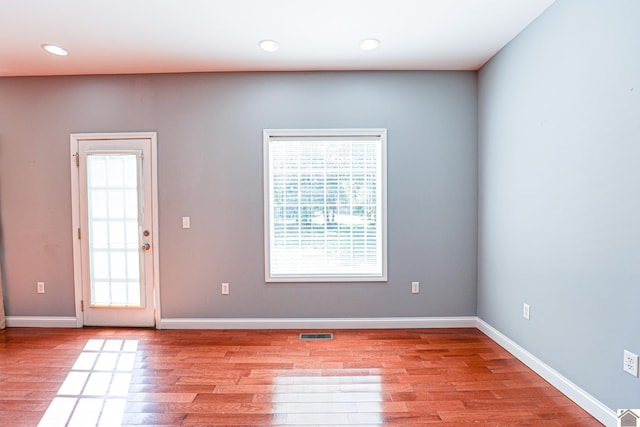 interior space with a wealth of natural light, visible vents, baseboards, and light wood finished floors