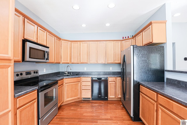 kitchen with light brown cabinets, light wood-style floors, appliances with stainless steel finishes, and a sink