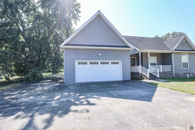 ranch-style home with a garage, covered porch, driveway, and roof with shingles