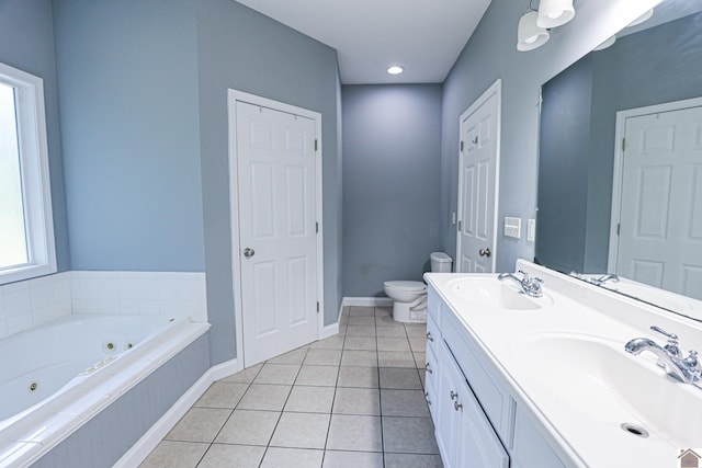 bathroom featuring a sink, toilet, a jetted tub, and tile patterned floors