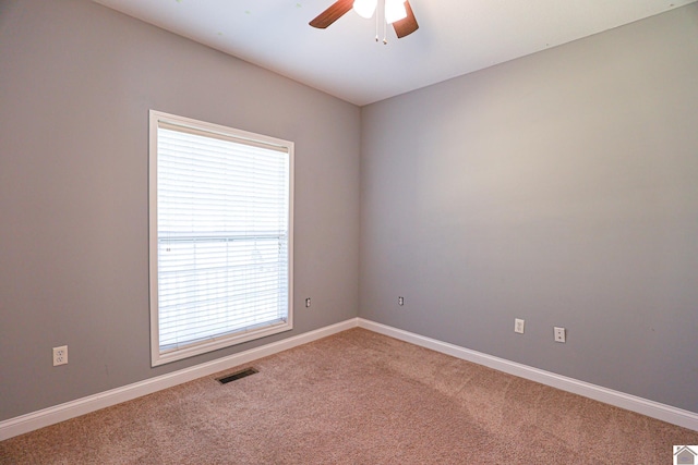 carpeted empty room featuring a ceiling fan, baseboards, and visible vents