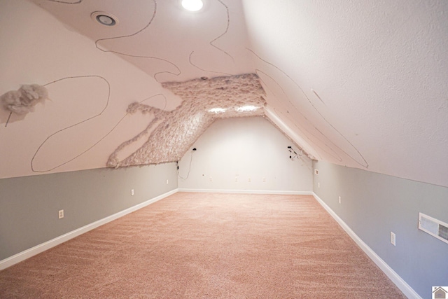 bonus room with a textured ceiling, visible vents, baseboards, and light carpet