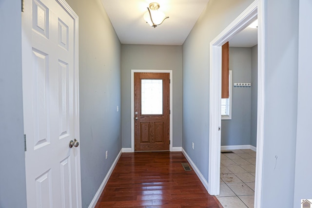 doorway to outside featuring visible vents, baseboards, and wood finished floors