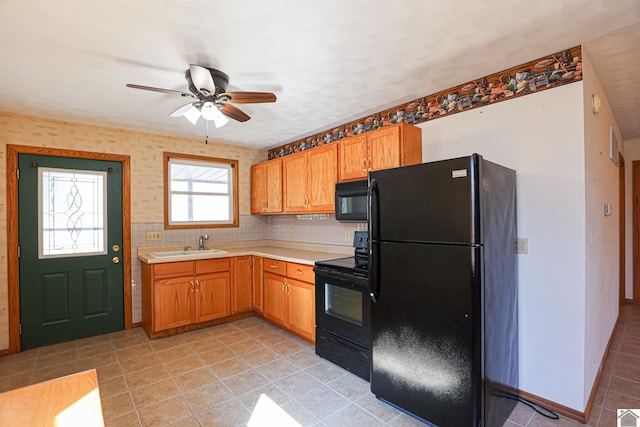 kitchen with light countertops, light tile patterned floors, decorative backsplash, black appliances, and a sink