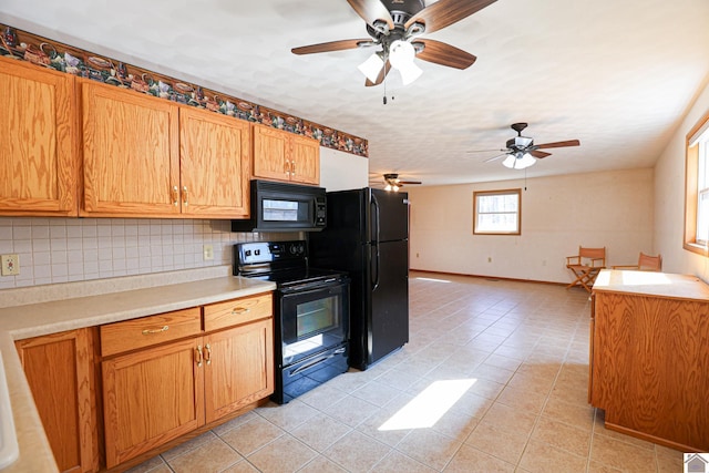 kitchen featuring tasteful backsplash, baseboards, light countertops, light tile patterned floors, and black appliances