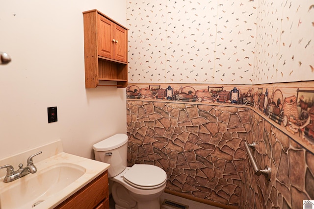 bathroom with vanity, toilet, and visible vents