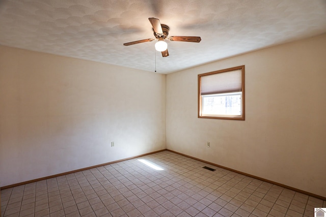 unfurnished room featuring visible vents, ceiling fan, a textured ceiling, and baseboards