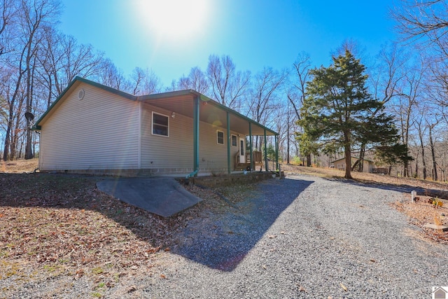 view of home's exterior with a porch and driveway