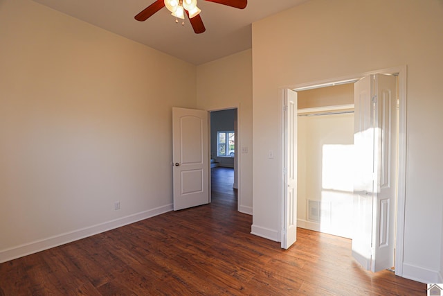 unfurnished bedroom featuring dark wood-style floors, ceiling fan, and baseboards