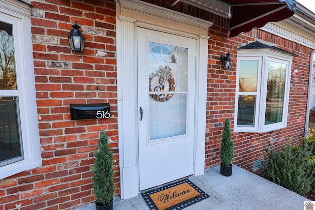 property entrance featuring brick siding