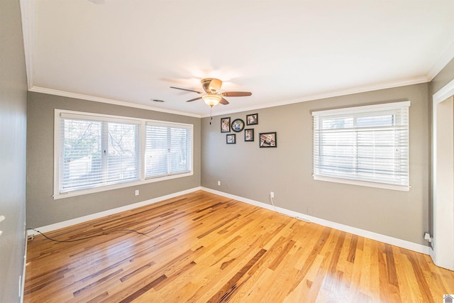 empty room featuring light wood finished floors, baseboards, and ornamental molding