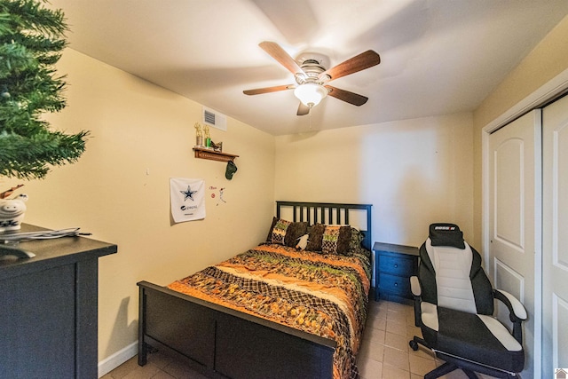 tiled bedroom featuring a ceiling fan, visible vents, and a closet