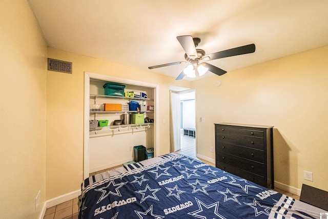 bedroom featuring tile patterned flooring, visible vents, baseboards, ceiling fan, and a closet