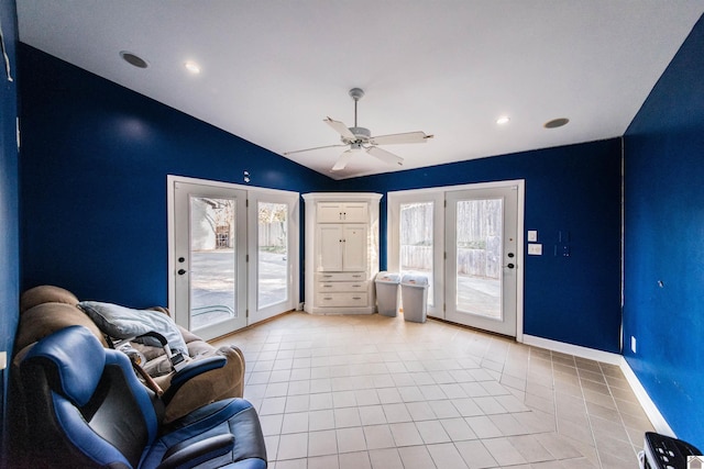 sitting room with light tile patterned floors, a ceiling fan, baseboards, and vaulted ceiling