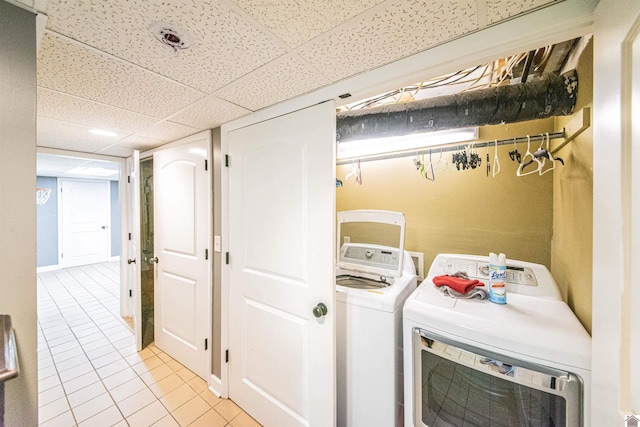 laundry room with light tile patterned floors, separate washer and dryer, and laundry area