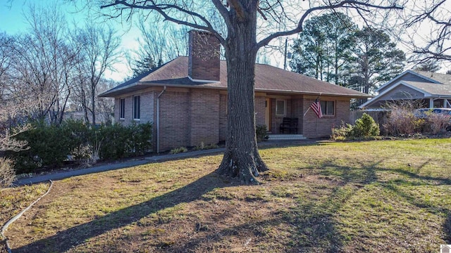 exterior space with a front yard, brick siding, and a chimney