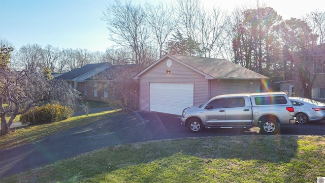 view of property exterior with an outbuilding, a lawn, and a detached garage