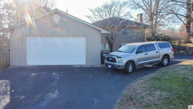 view of side of home featuring a garage, an outbuilding, and a chimney